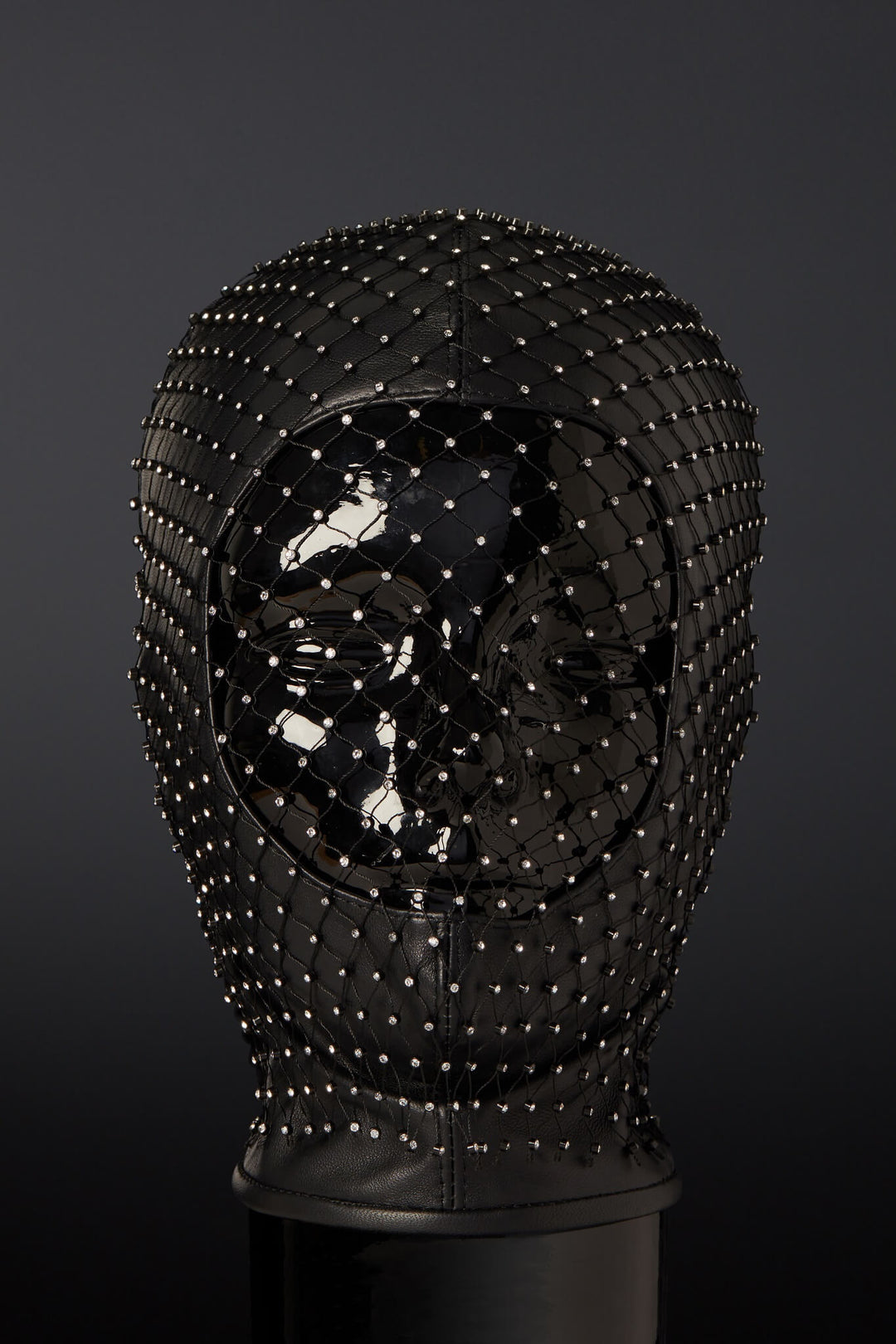 An elegant black leather hood with a mesh fabric veil adorned with rhinestones, designed to fit most head sizes.