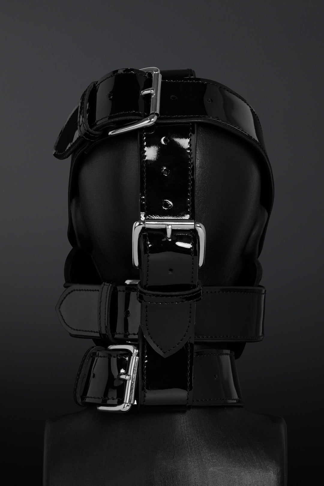 Black leather straps with silver buckles on a dark background