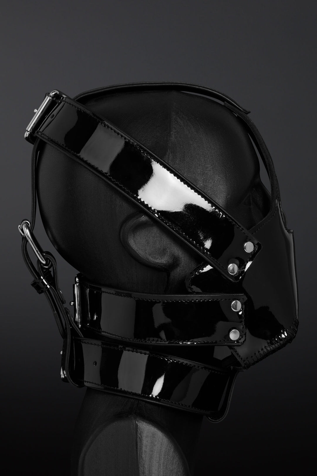Black glossy mask with straps on a dark background