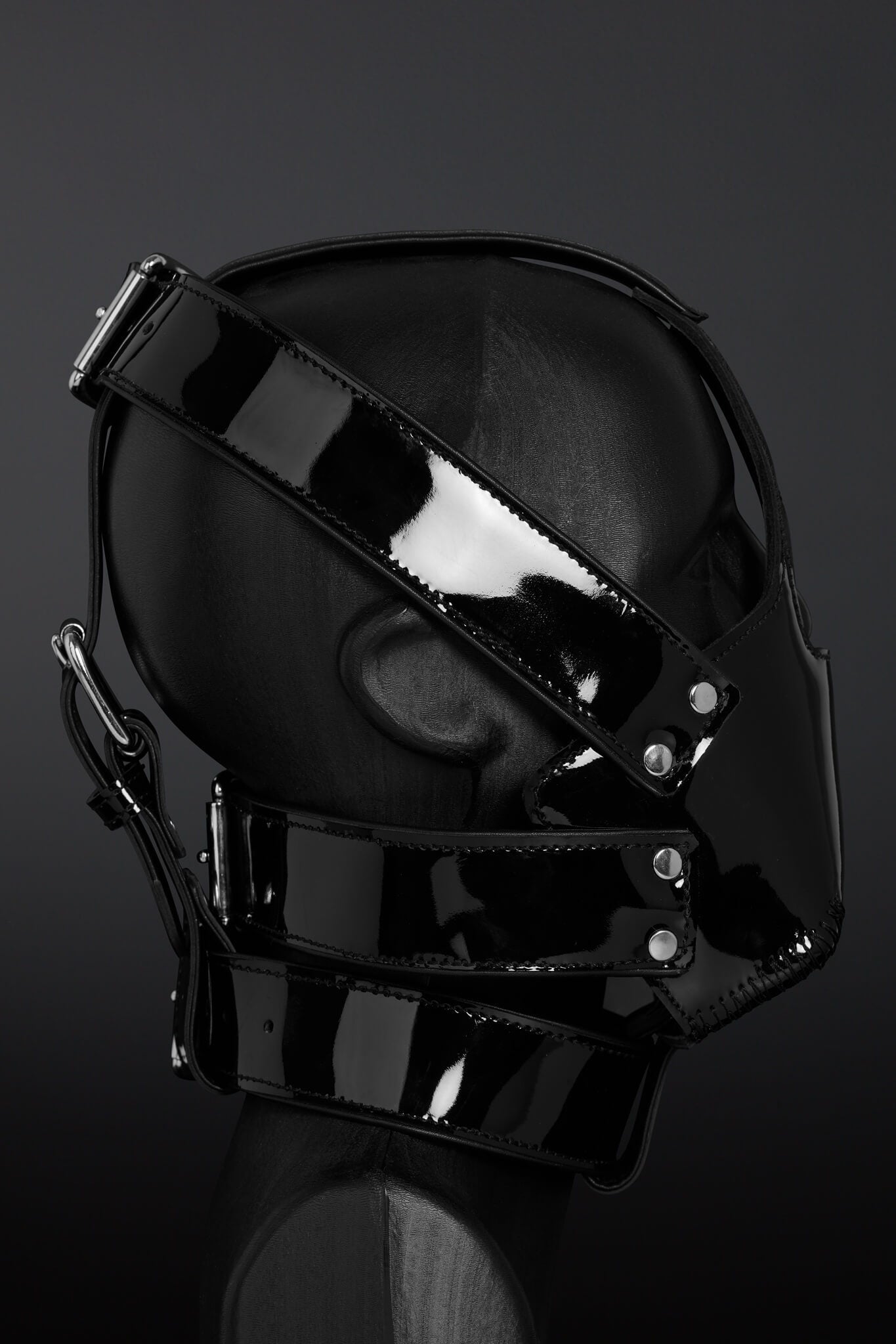 Black glossy mask with straps on a dark background