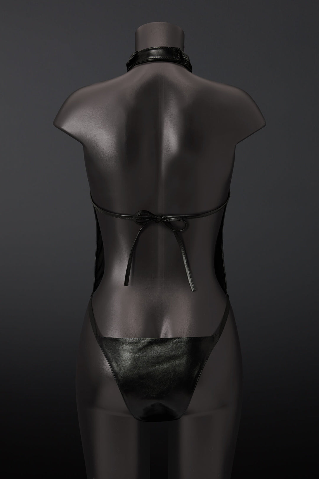 Black leather outfit on a mannequin against a dark background