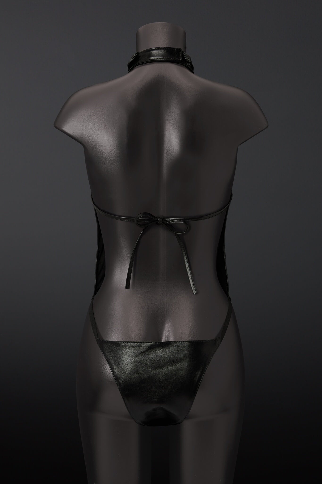 Black leather outfit on a mannequin against a dark background