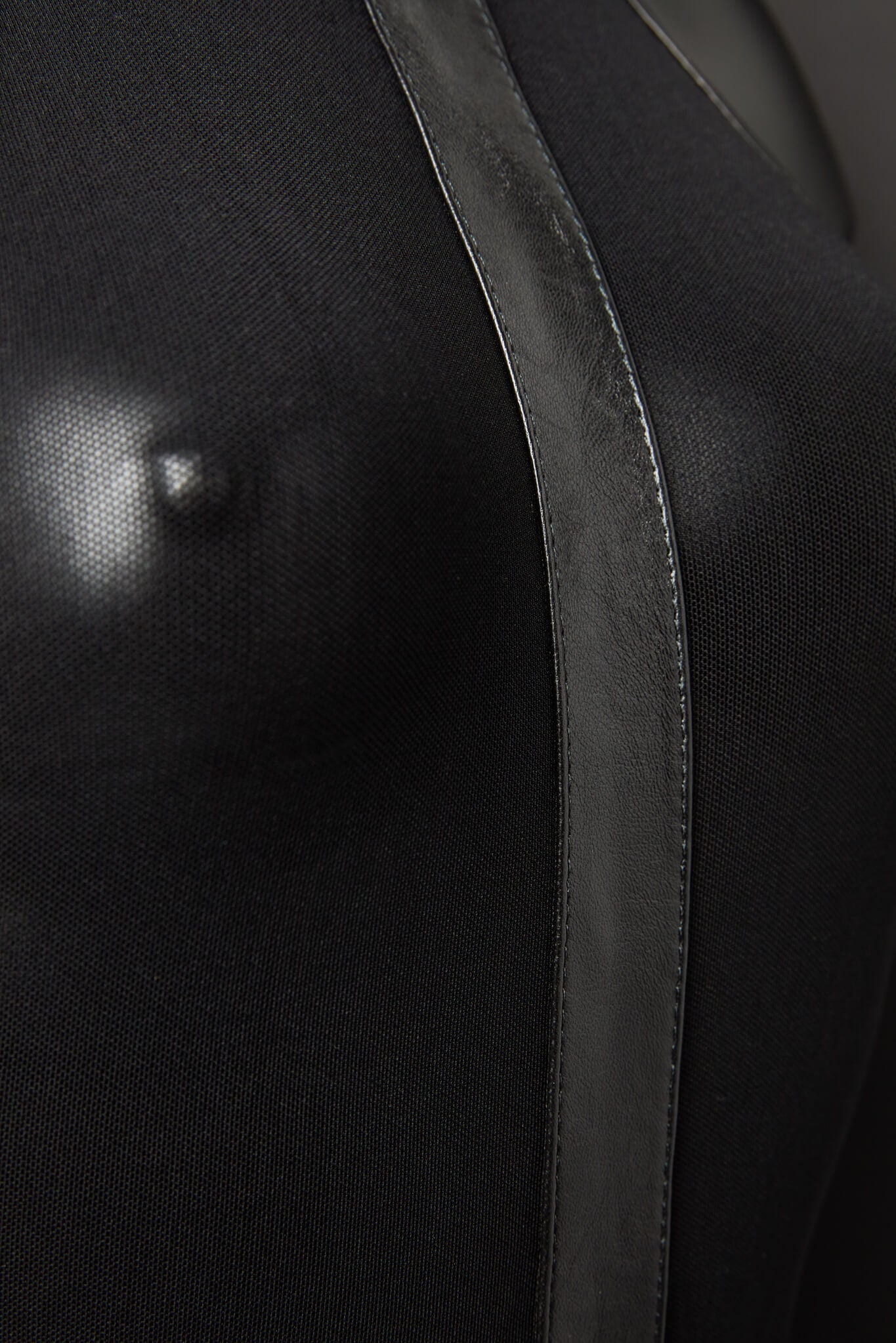 Close-up of a black garment with a satin trim