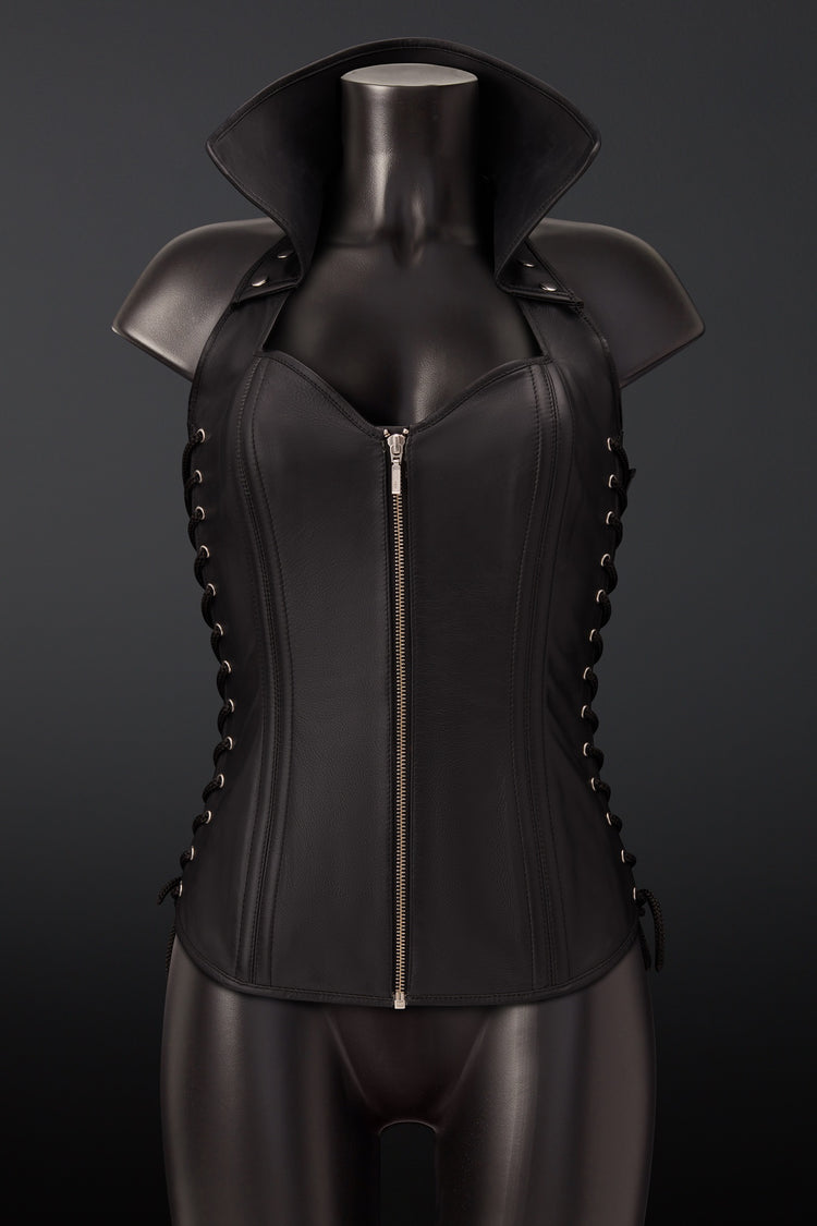 Black leather corset vest with shoulder armor and side lacing, displayed on a black mannequin torso against a dark gray background.