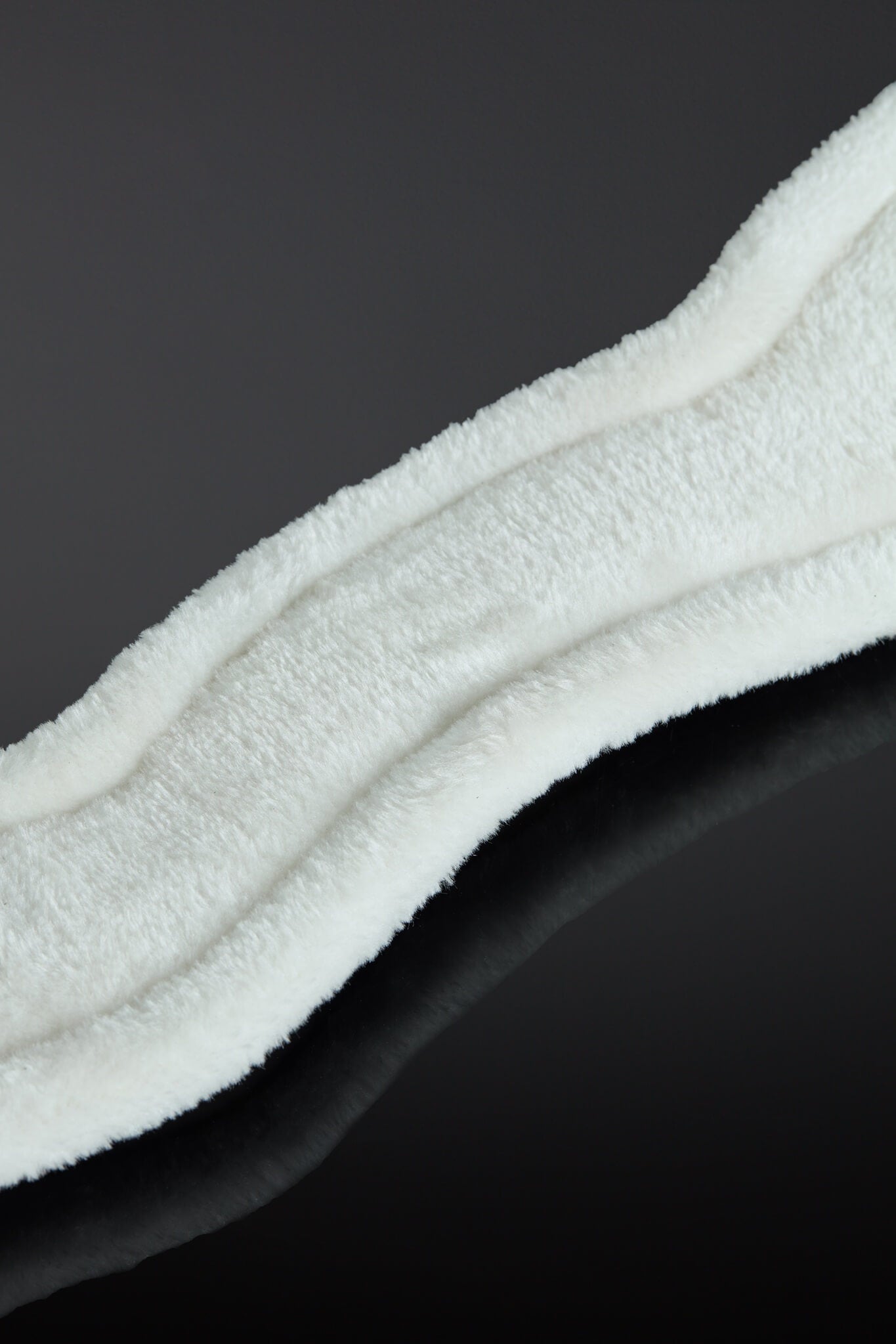Close-up of a white textured faux fur strip on a black background