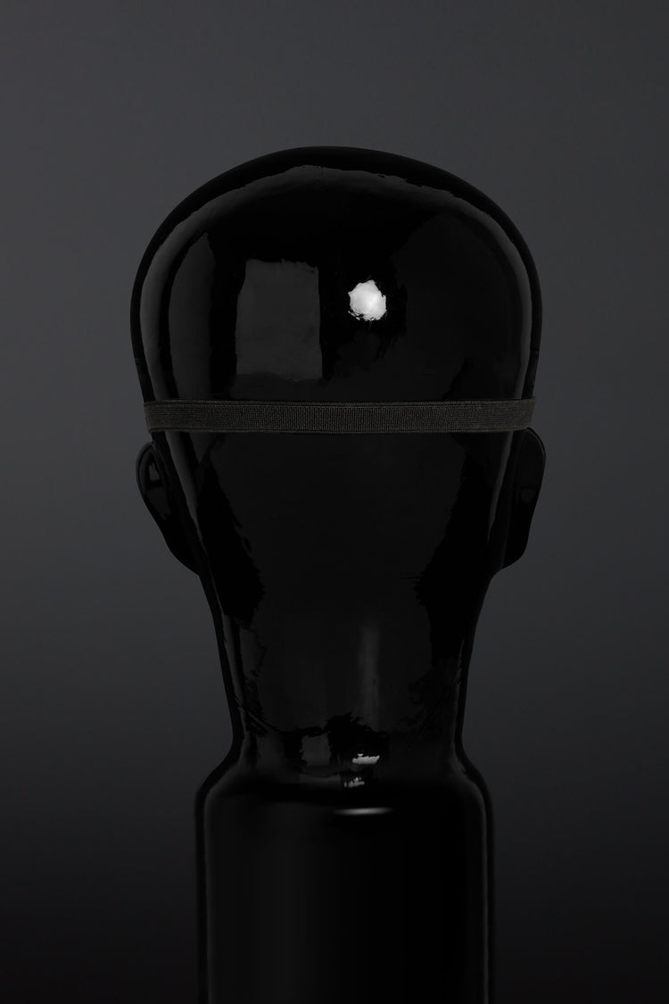 Black blindfold on a dark background - rear of head view