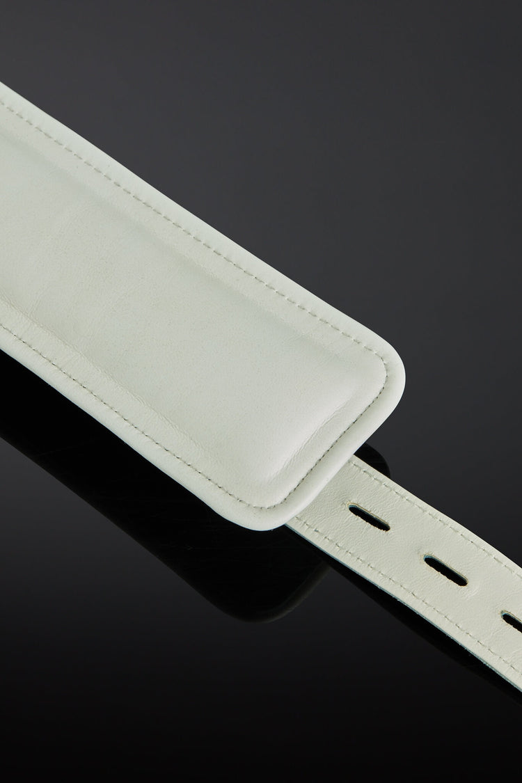 sea green color wrist cuffs on a black background - close up shot o interior white leather