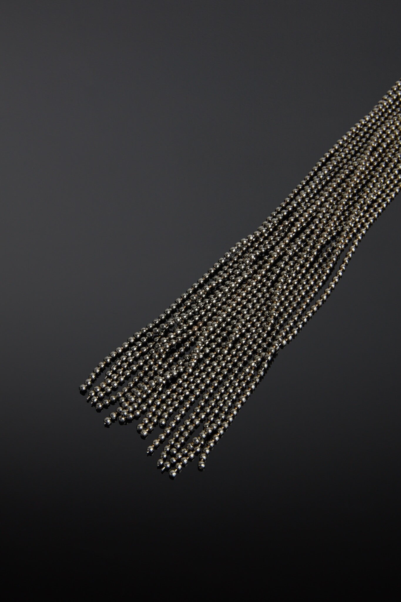 String of black ball chainbeads on a dark background