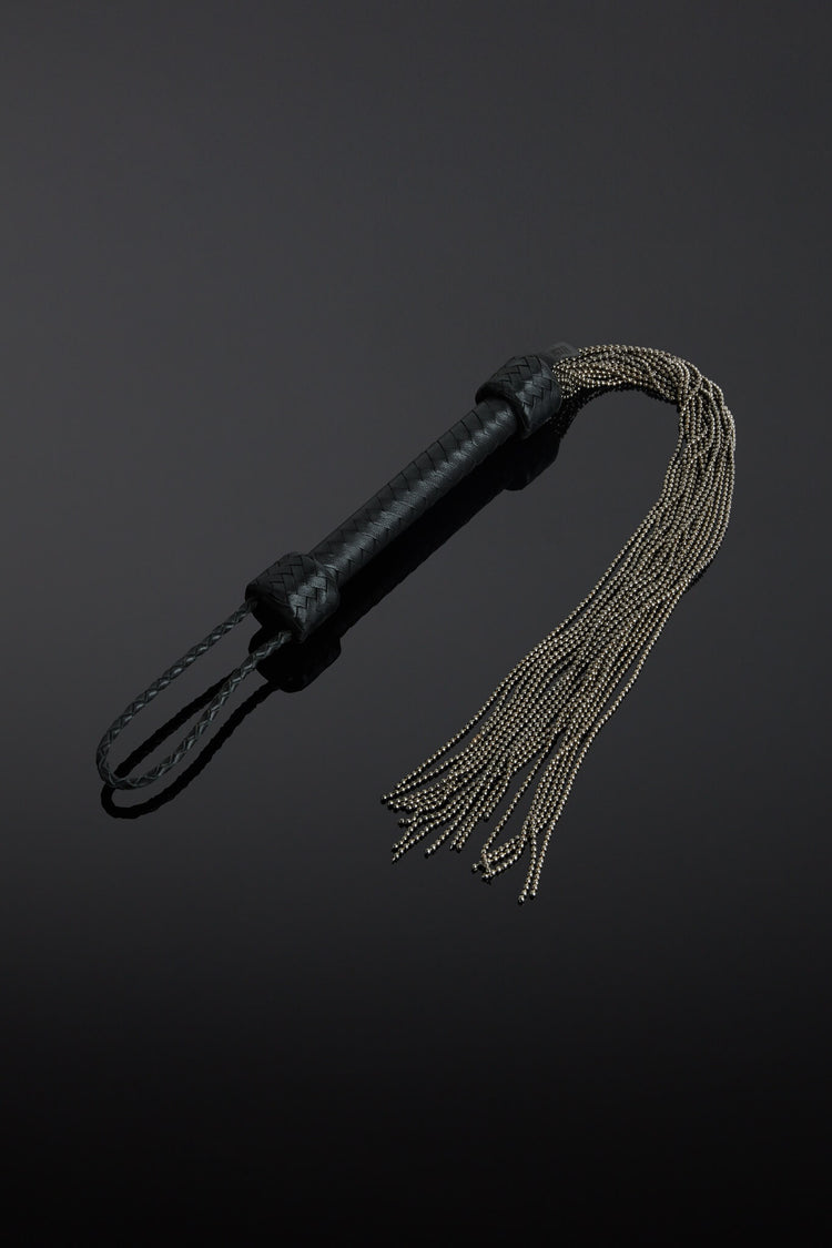 Dark black leather ball chain flogger on black background