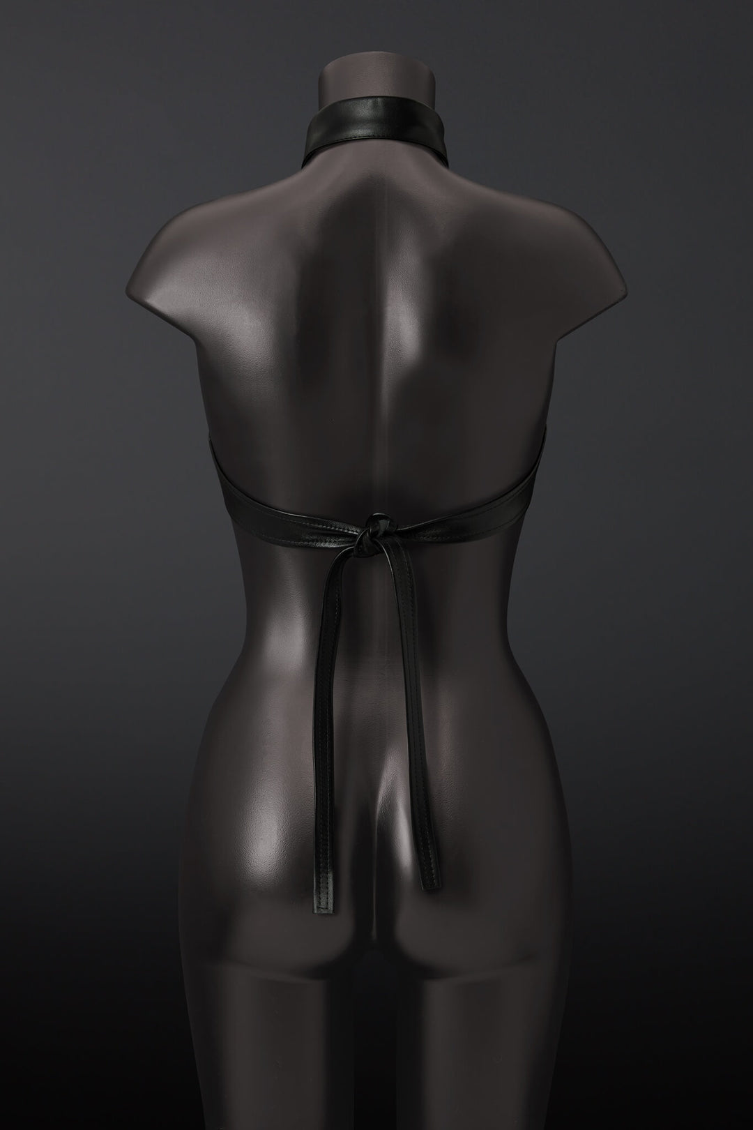 Black leather outfit on a mannequin against a dark background