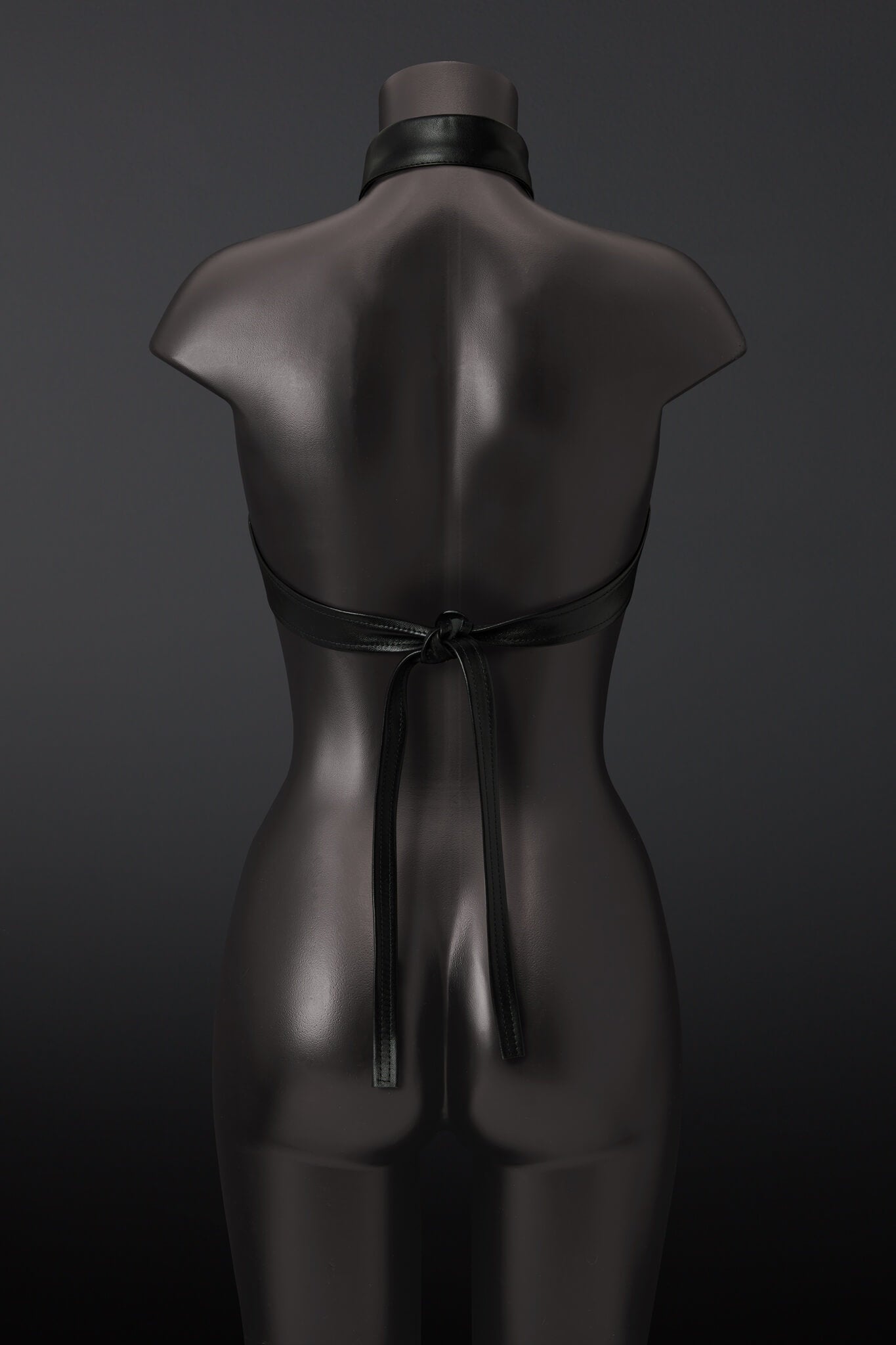 Black leather outfit on a mannequin against a dark background