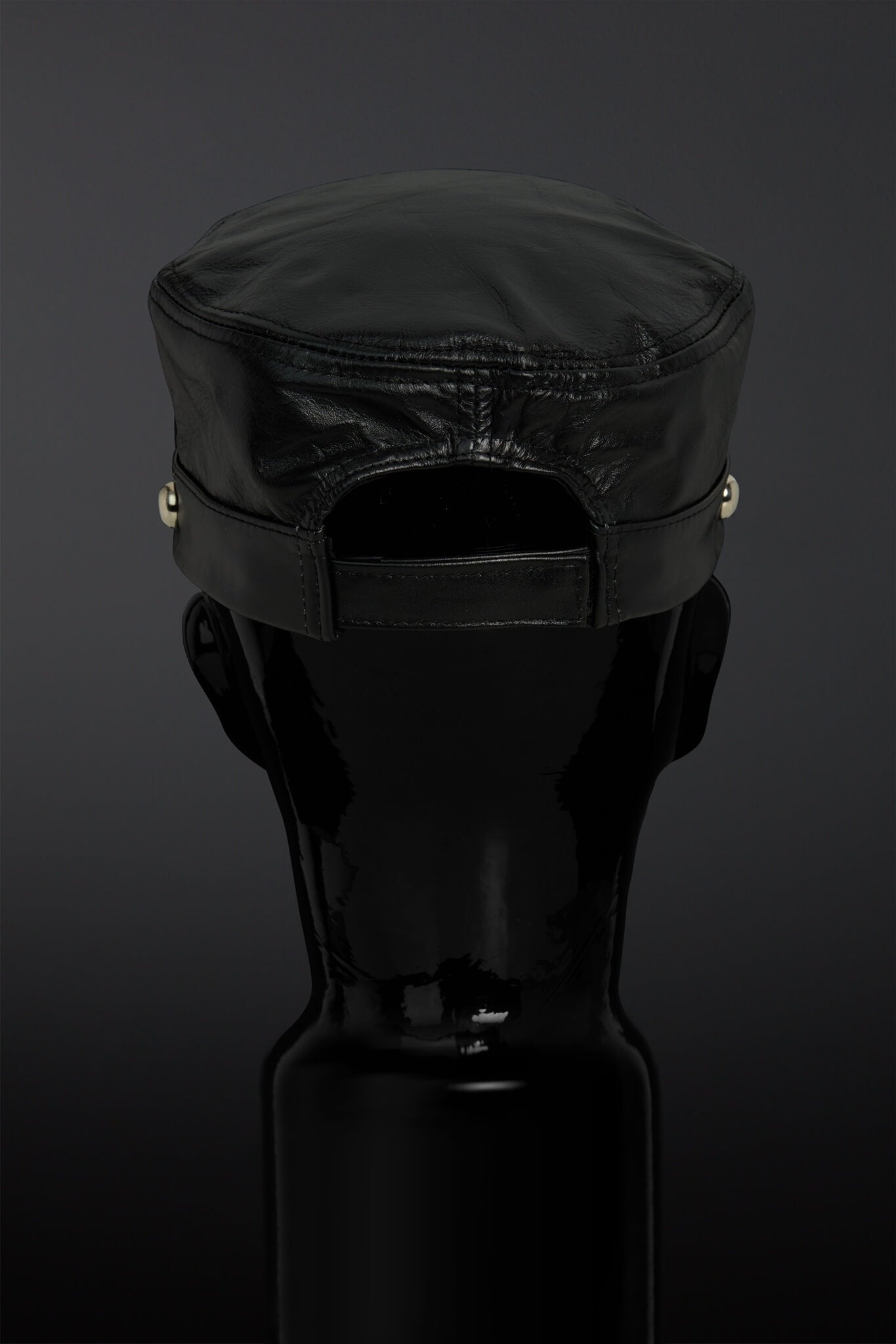 Black cap on a black mannequin head against a dark background