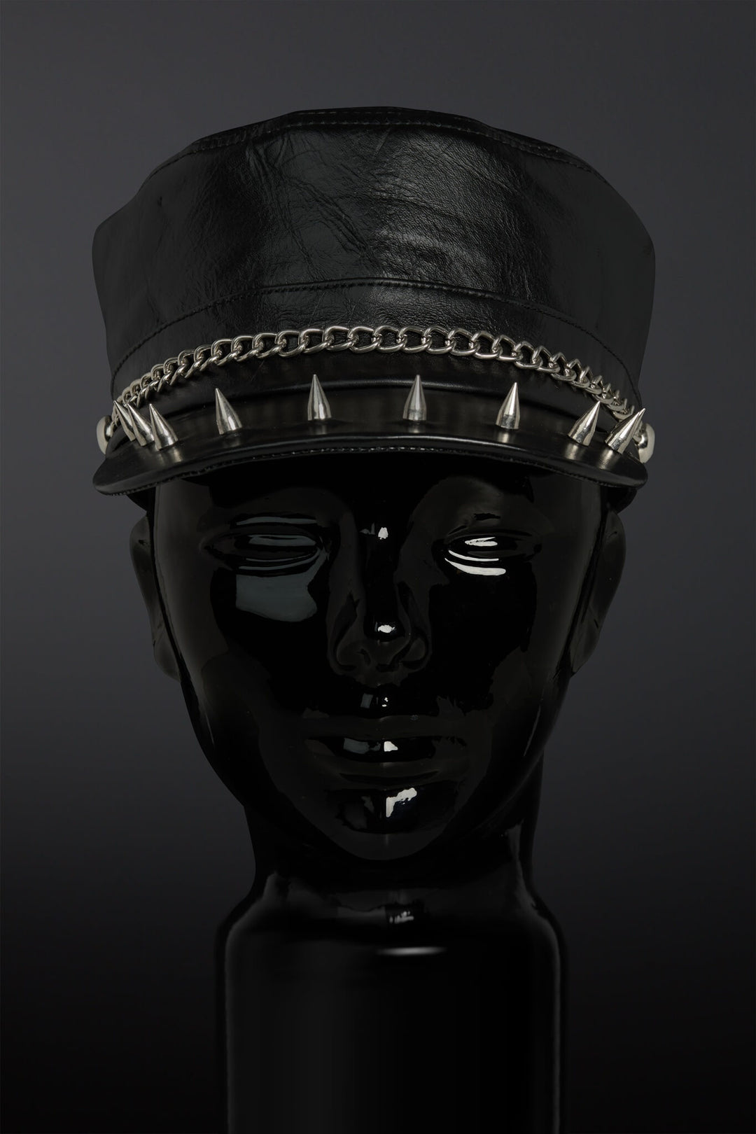 Black leather cap with spikes on a dark background