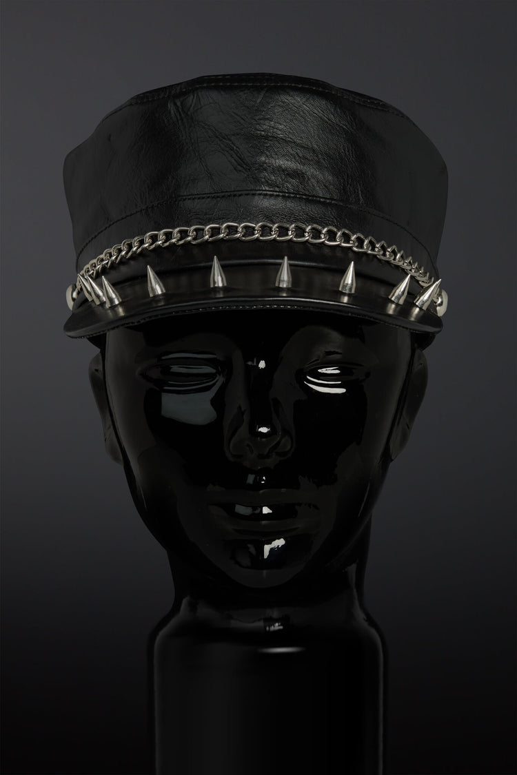 Black leather cap with spikes on a dark background