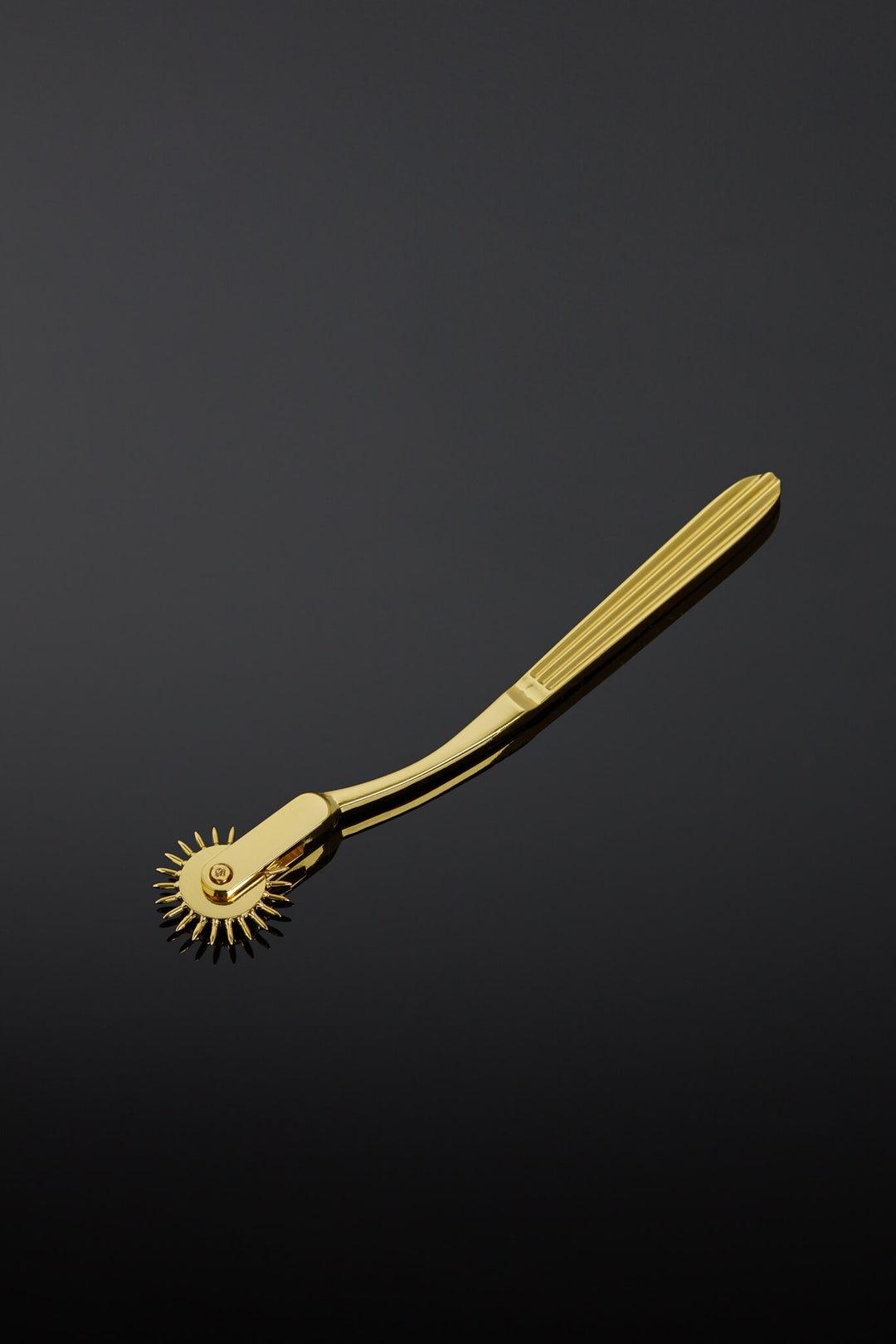 Gold-colored medical tool on a black background