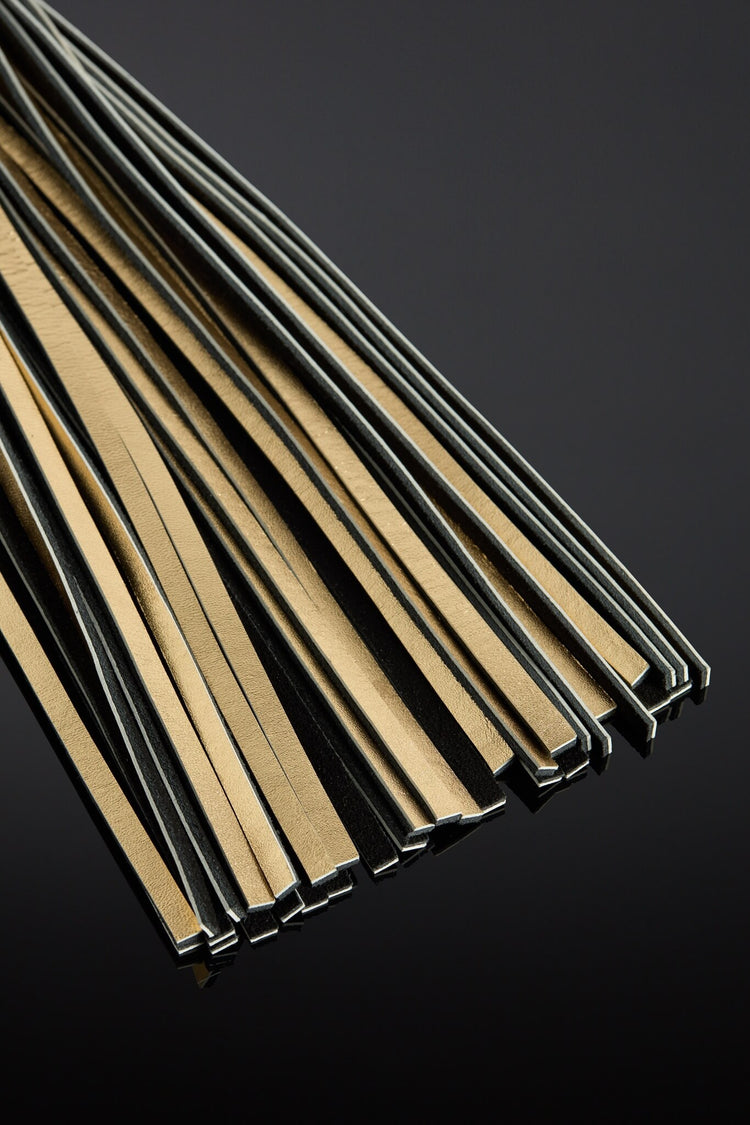 Gold leather tail strips on a black background