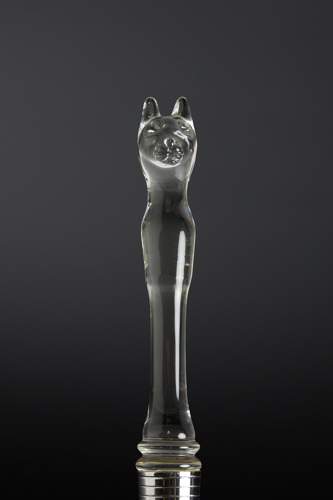 Clear glass object shaped like a cat on a black background
