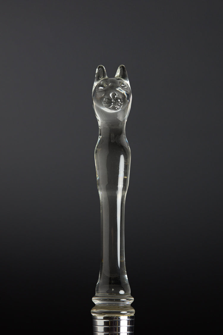 Clear glass object shaped like a cat on a black background