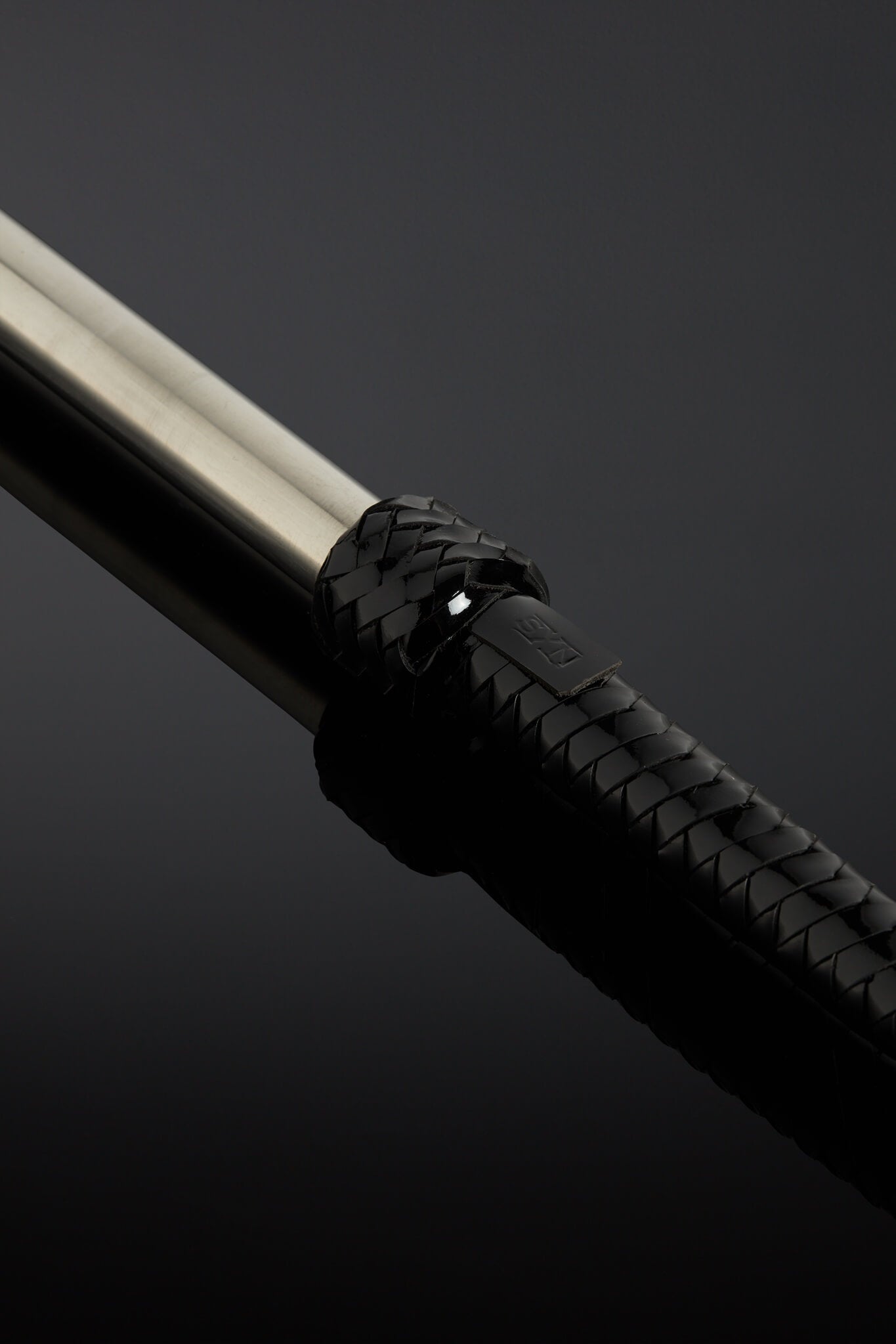Close-up of a black handlebar with a metallic end on a dark background