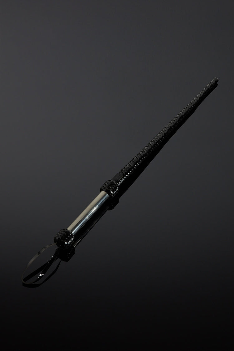 Black leather whip with metal handle on a dark background