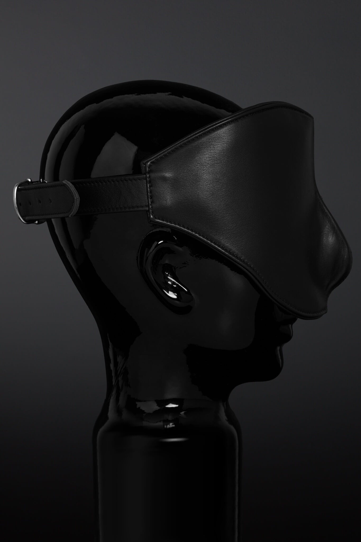Black leather blindfold on a dark background