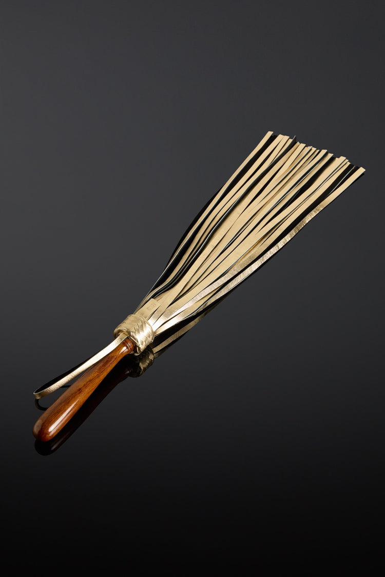 Flogger with wooden handle on a black background