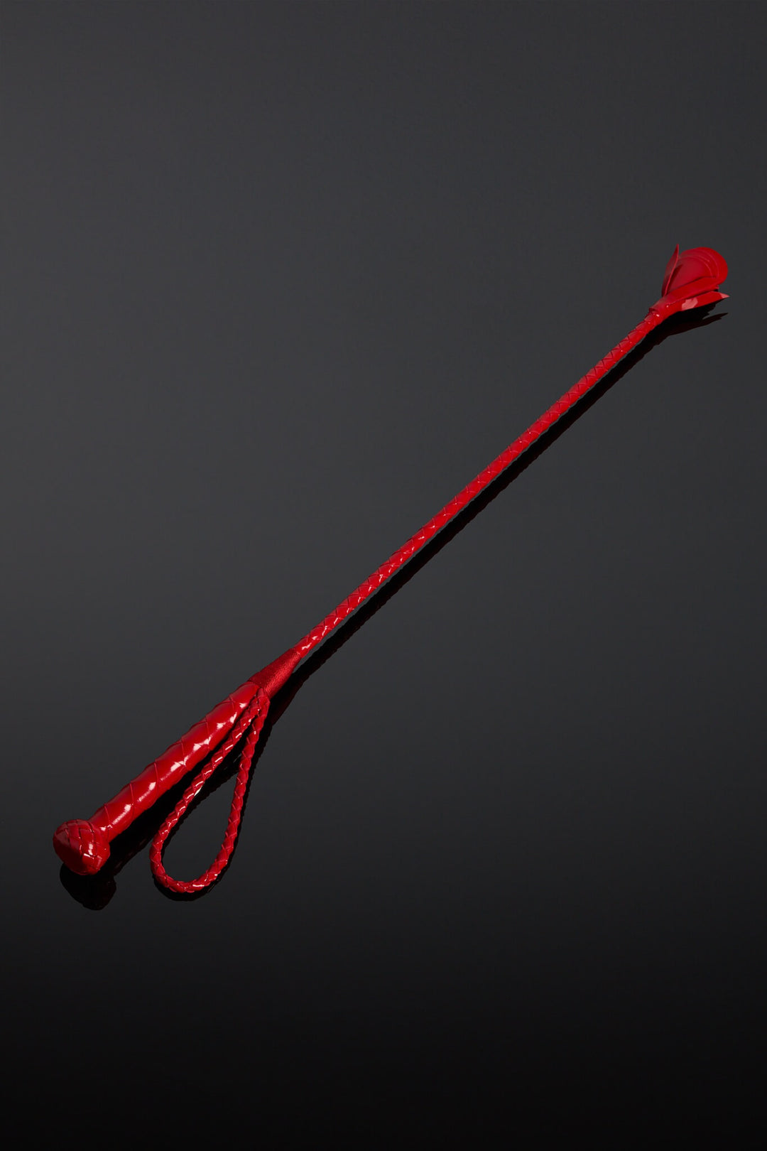 Red leather crop on a black background