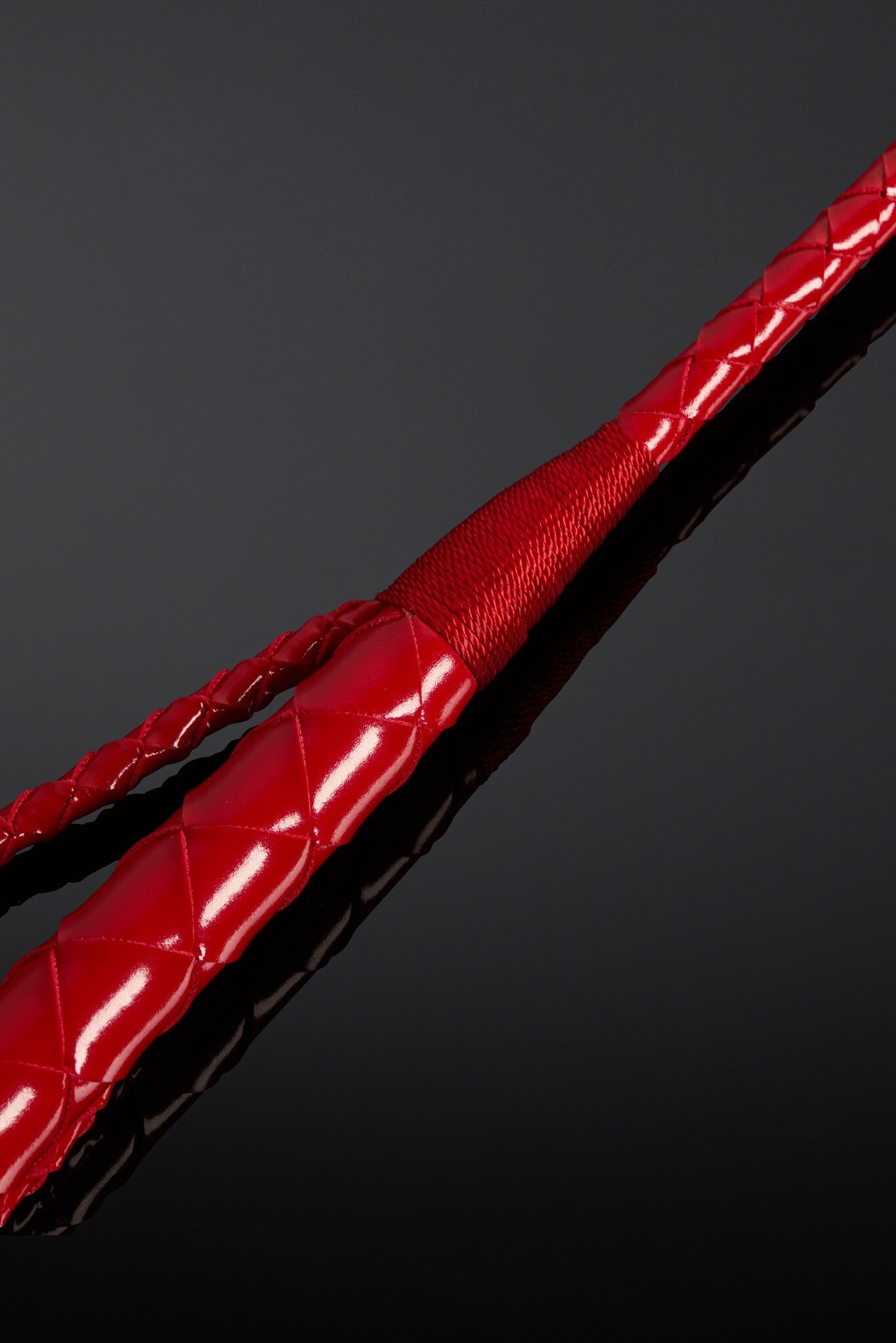 Closeup of leather crop. Red color on black background