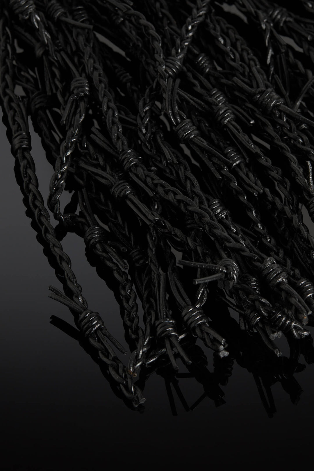 Close-up of barbed wire against a black background