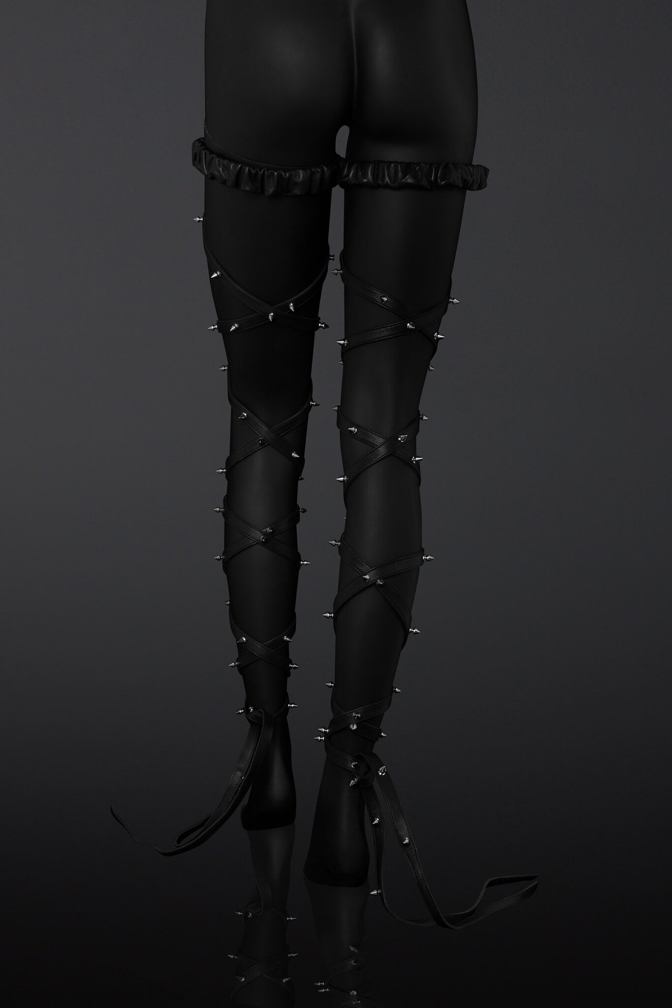 Black leather leg straps with metal spikes designs on a  mannequin legs over a dark background