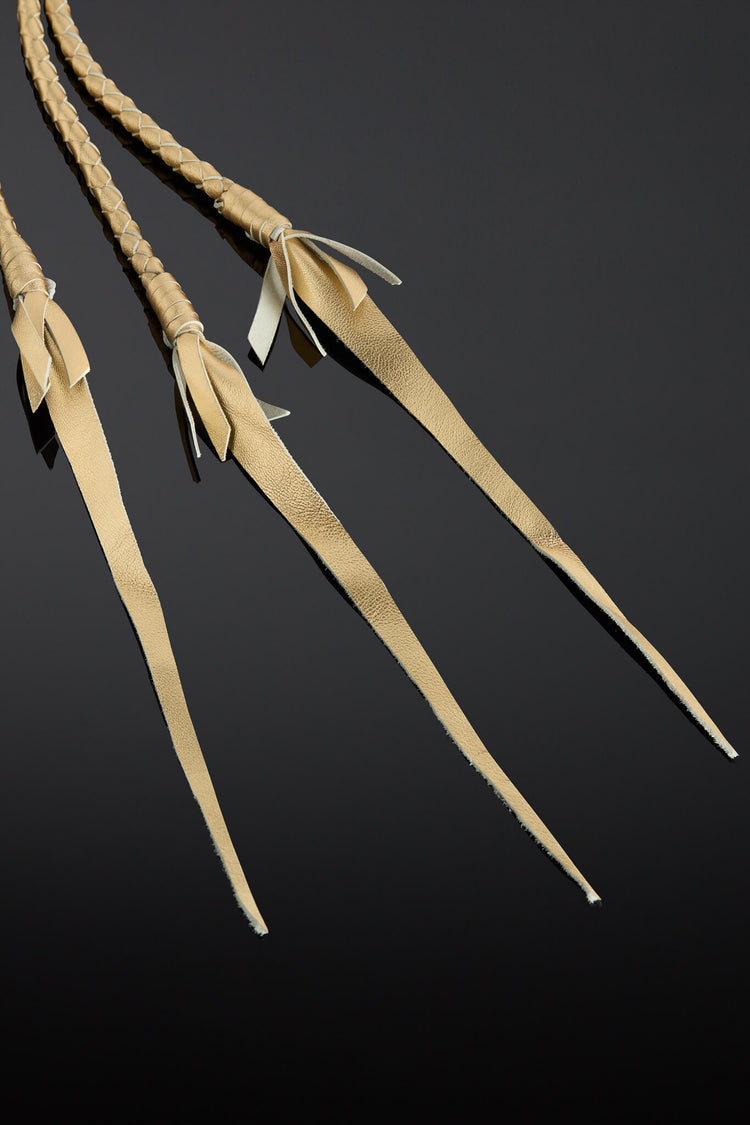 Three leather straps with braided ends on a black background