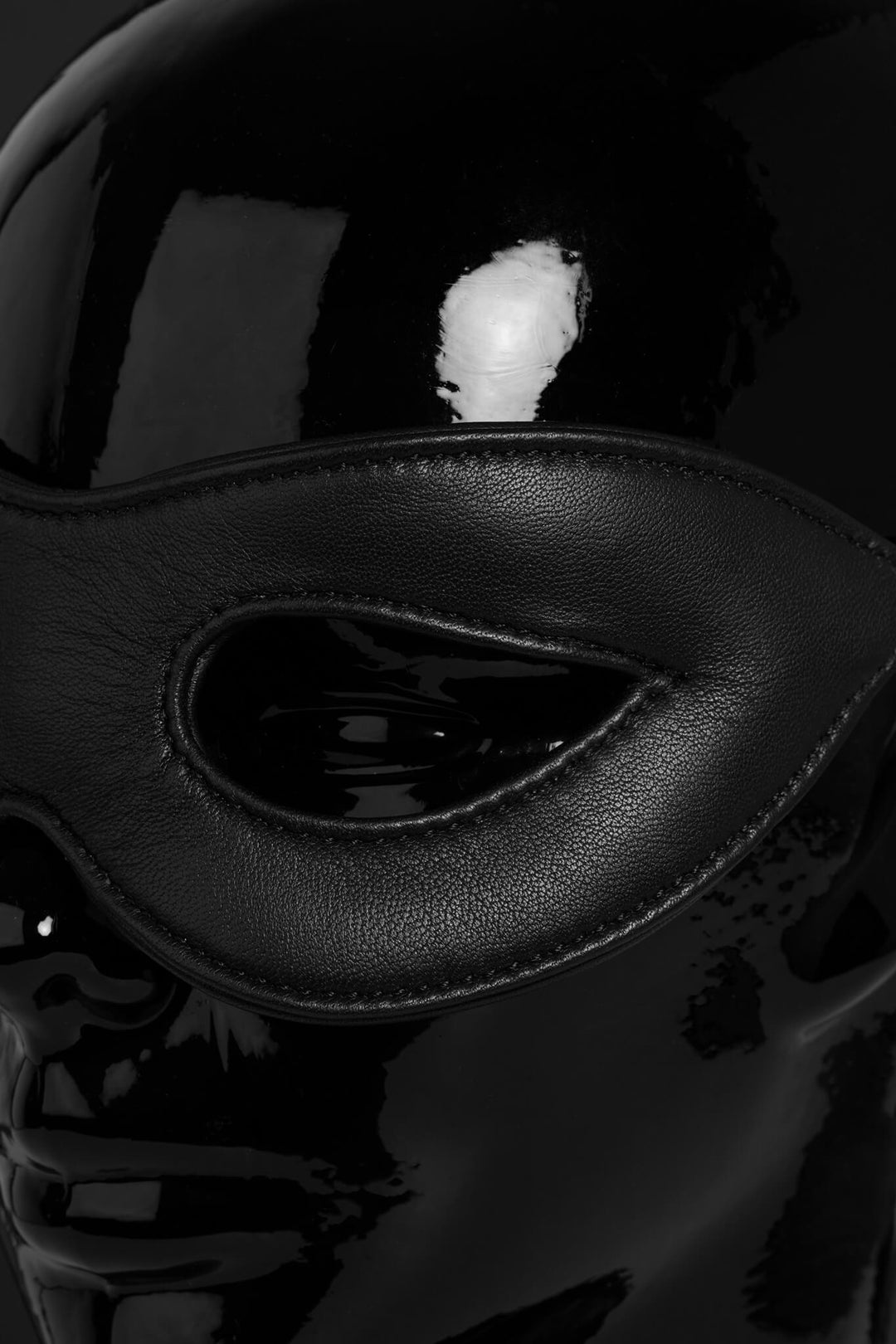 Close-up of a black leather mask with a reflective surface