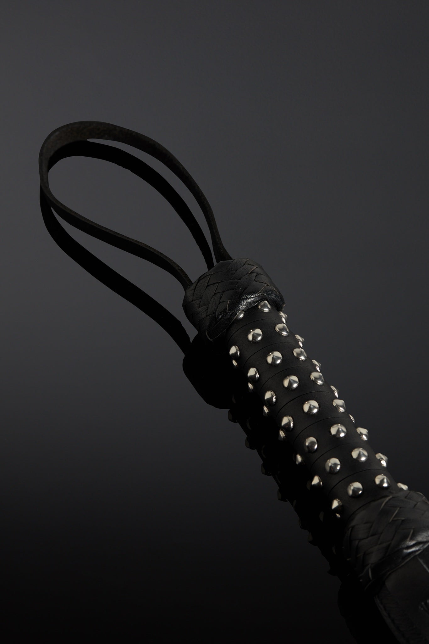 Black studded leather whip handle with studs on it