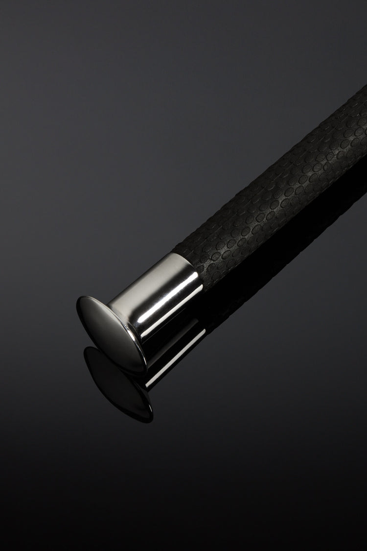 Close-up of a black textured cane handle with a silver ferrule on a dark background