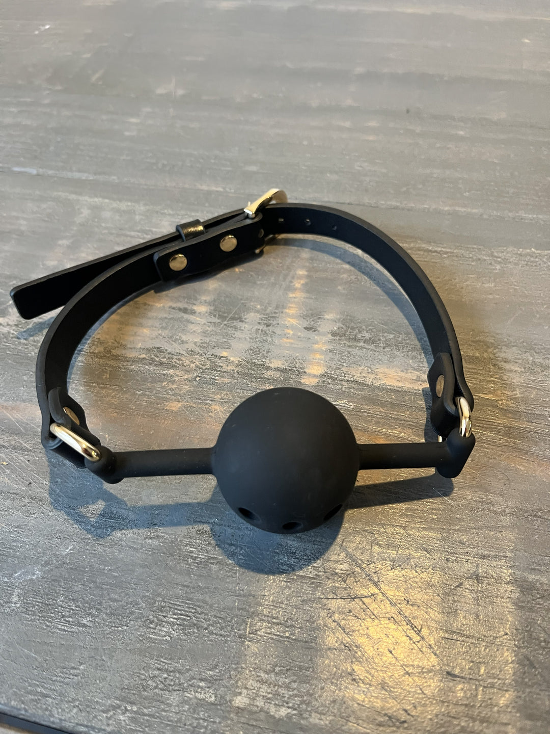 Black ball gag on a wooden surface