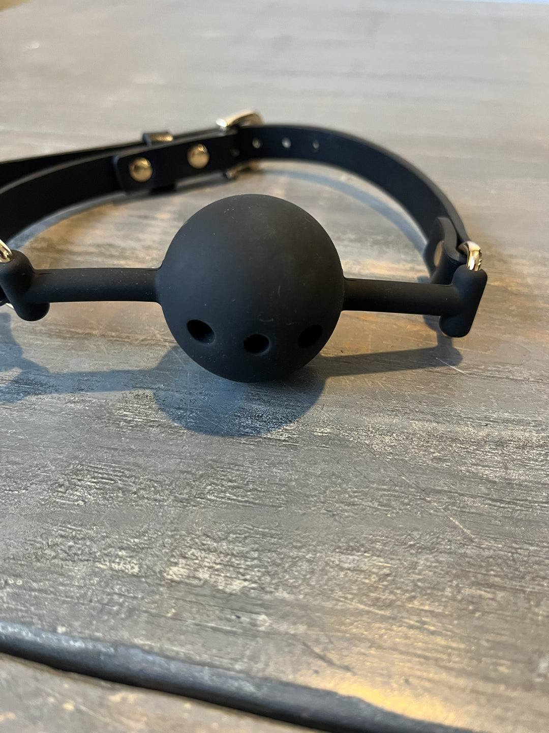 Black ball gag on a wooden surface