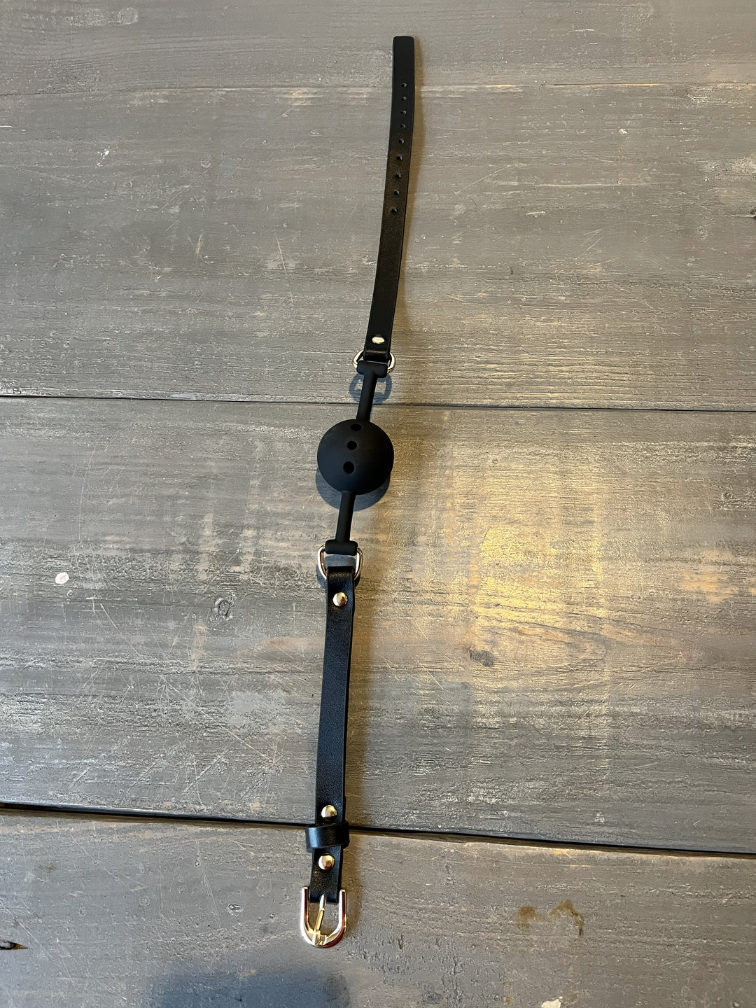 Black ball gag on a wooden surface