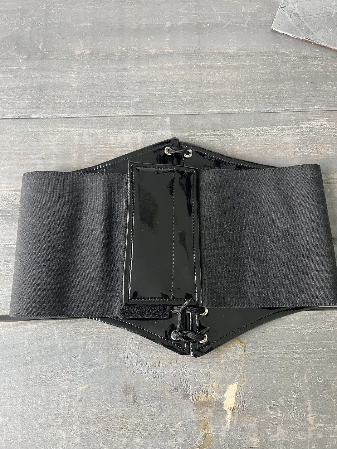 Black leather belt on a gray surface