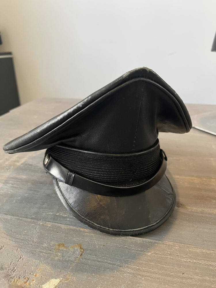 Black leather visor cap on a wooden surface