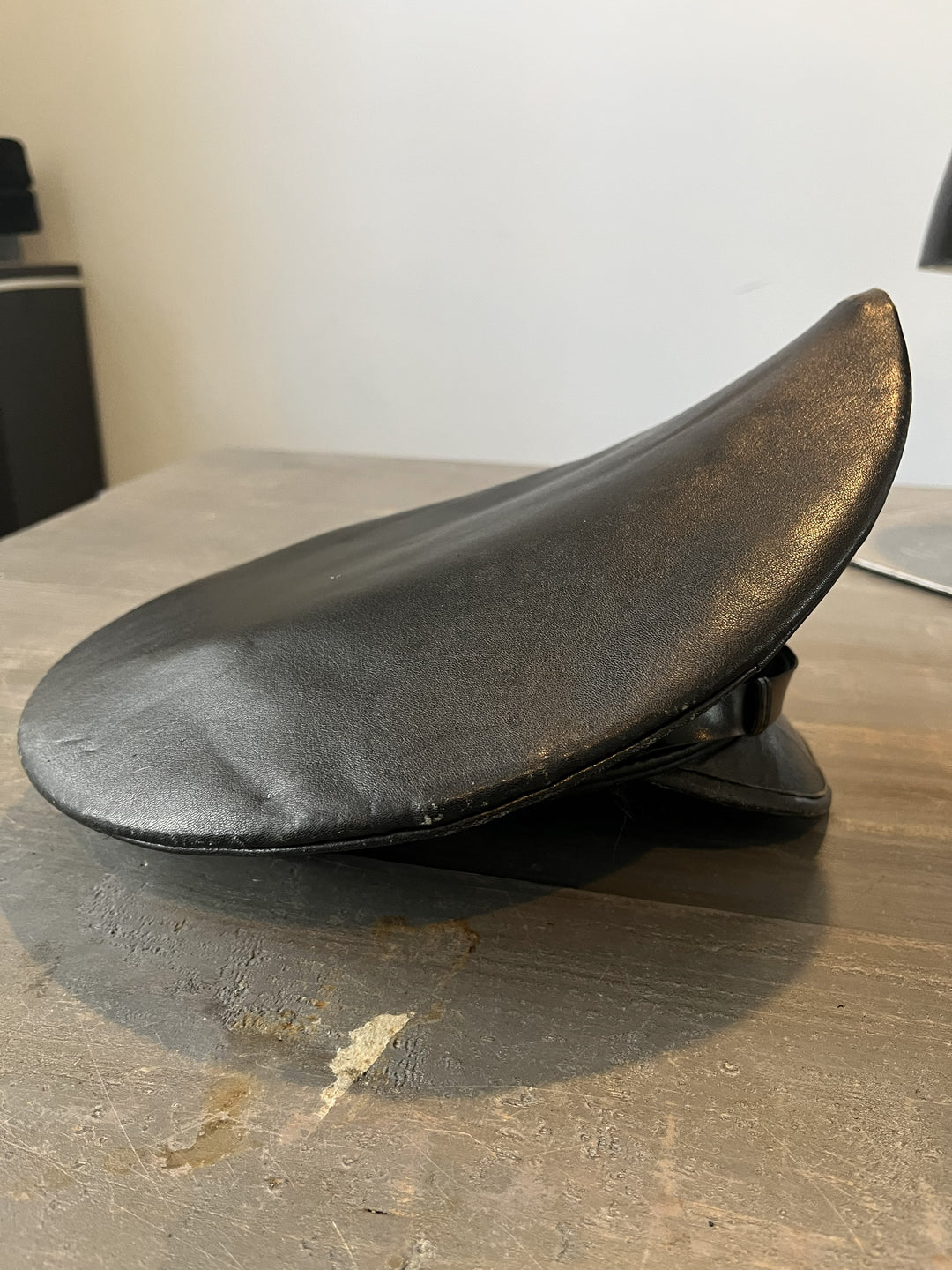 Black leather motorcycle seat on a wooden surface