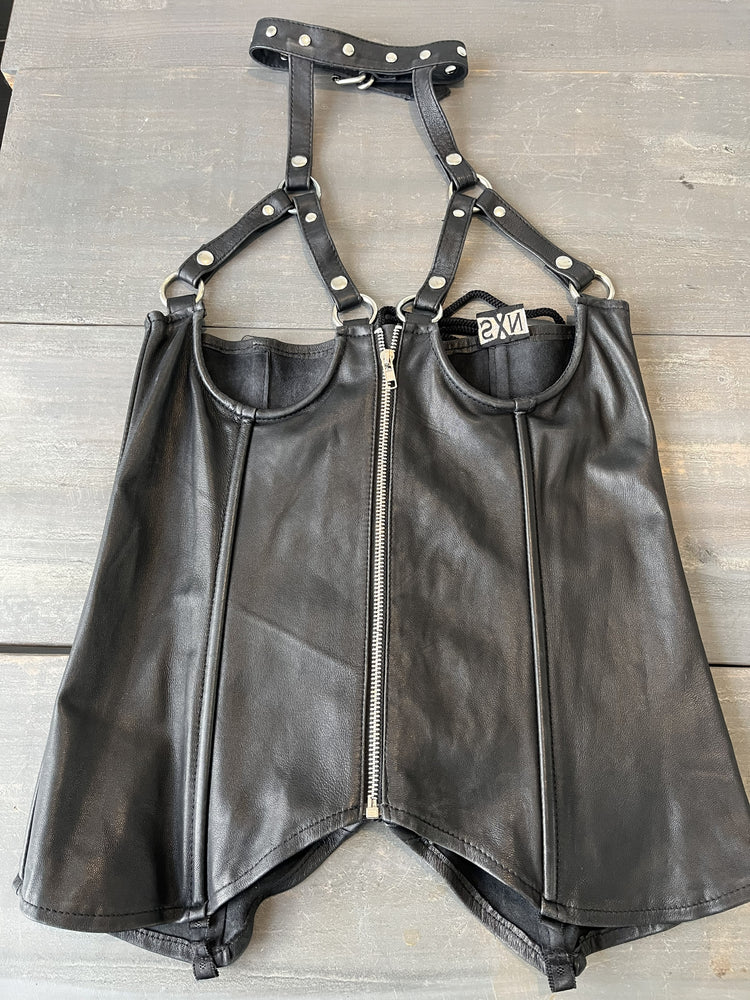 Black leather harness with studded details on a wooden surface