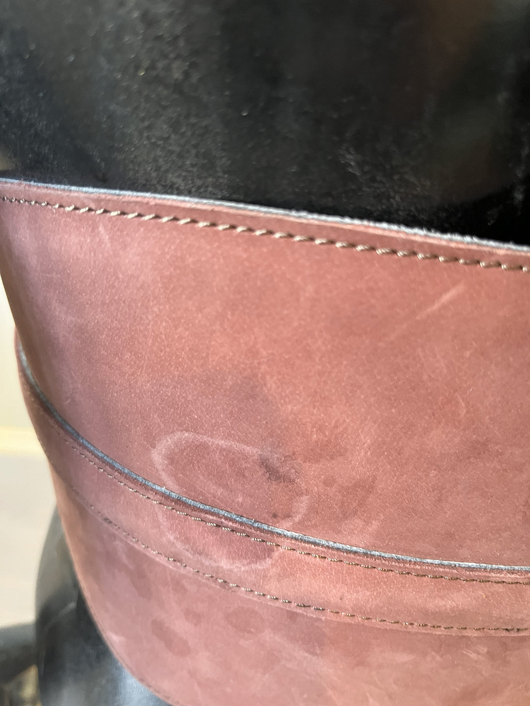 Close-up of a brown leather surface with visible stitching