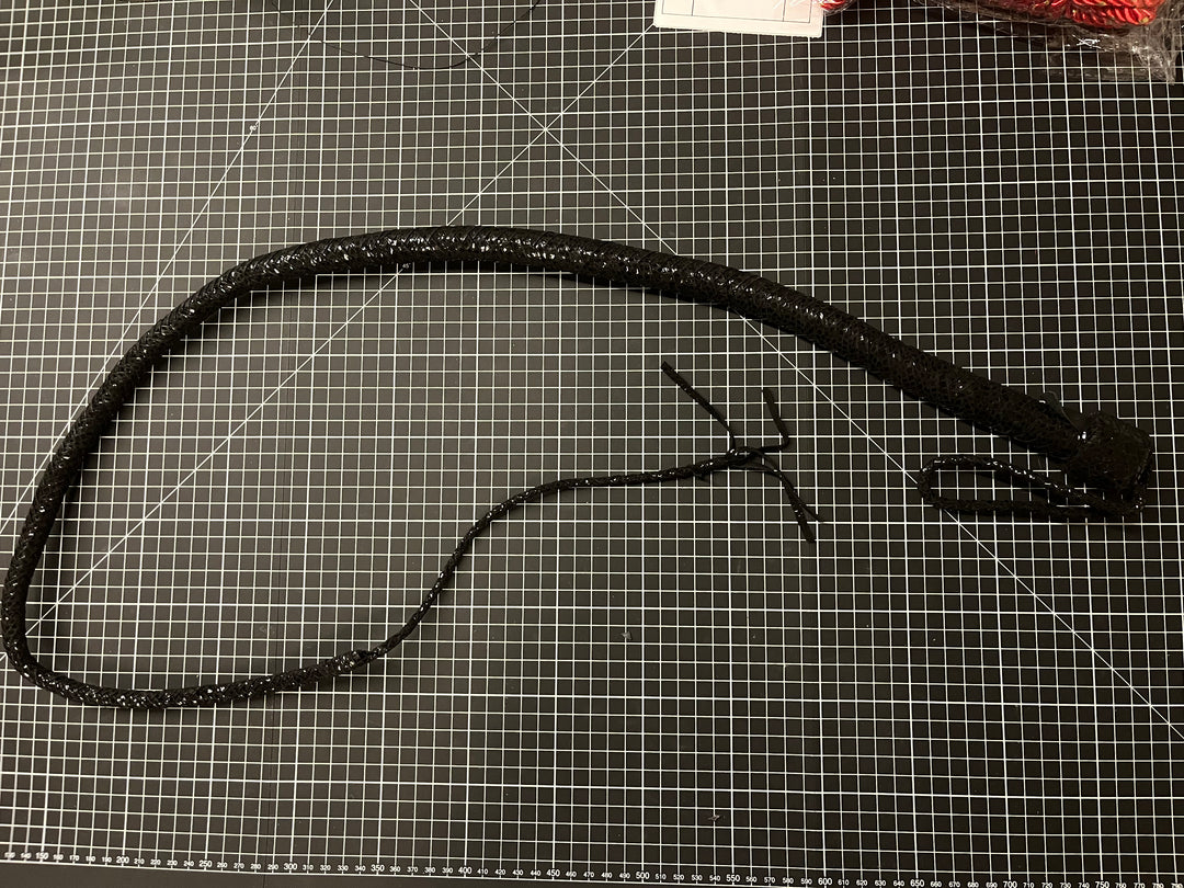 Black leather belt with a clasp on a grid surface