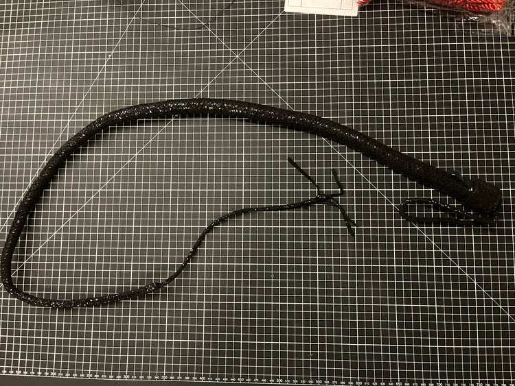 Black leather belt with a clasp on a grid surface