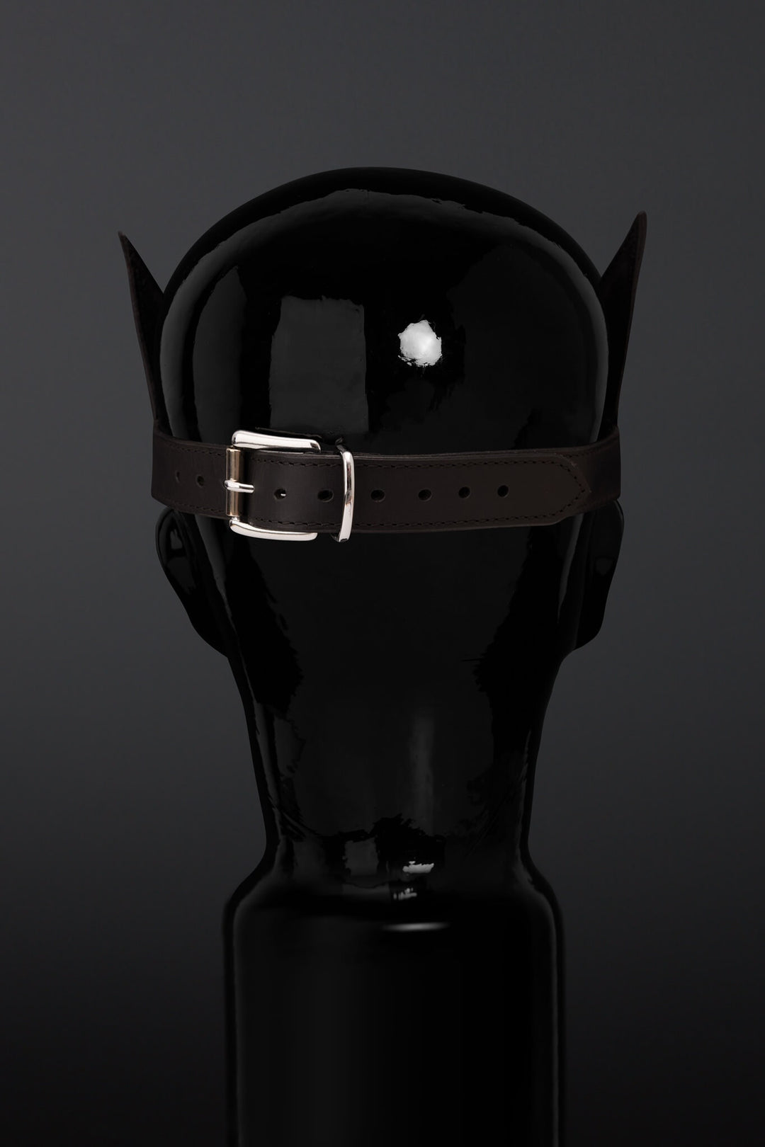 Rear view of lather madk on a mannequin head on a black/ gray background. 