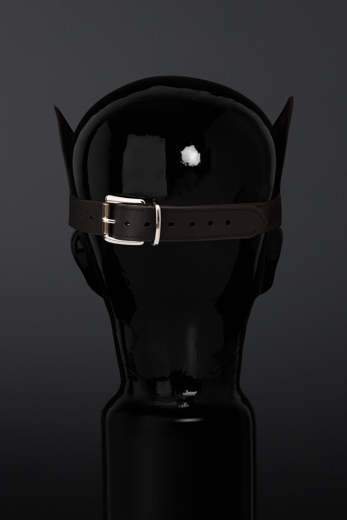 Rear view of lather madk on a mannequin head on a black/ gray background. 