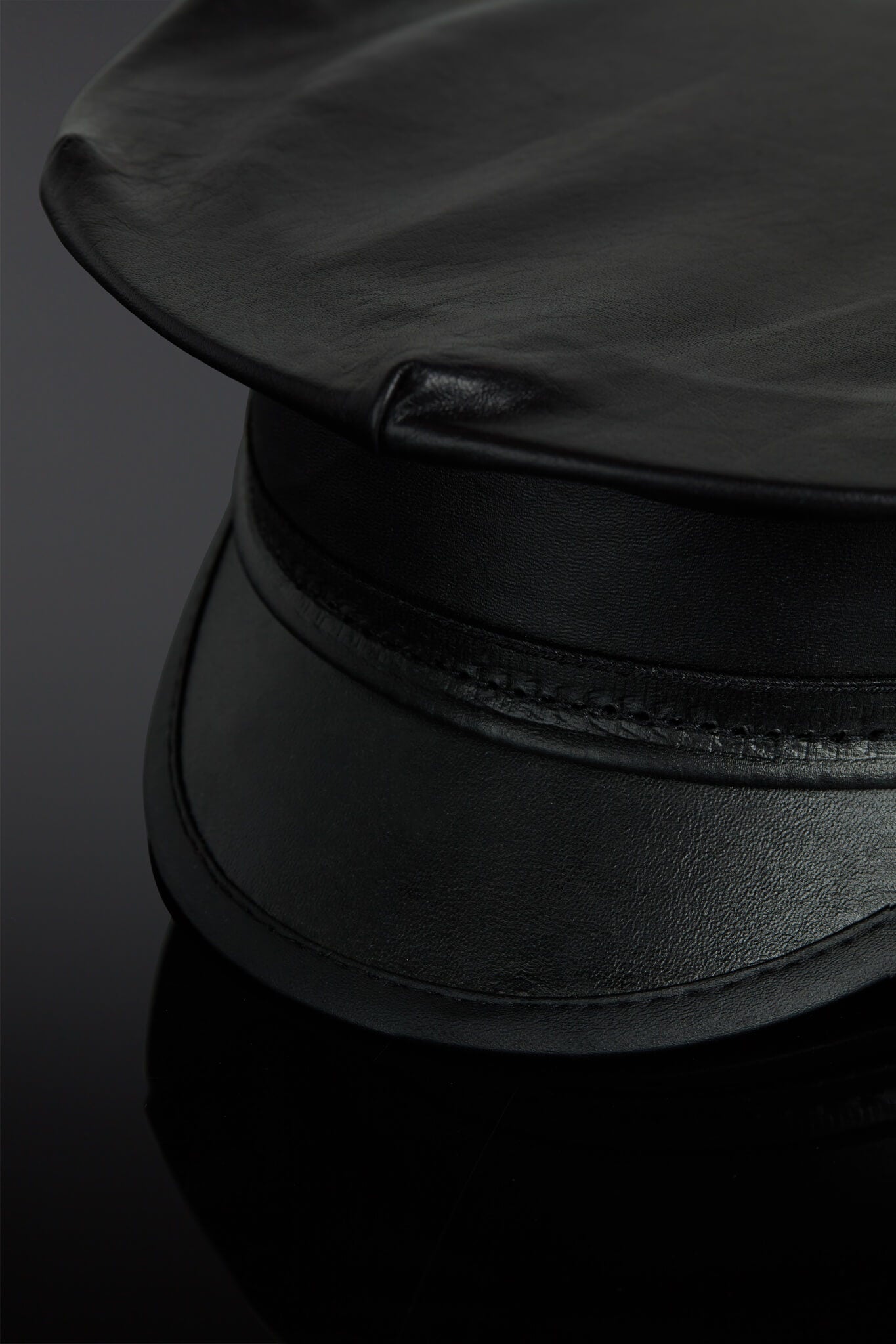 Black leather hat on a reflective black surface