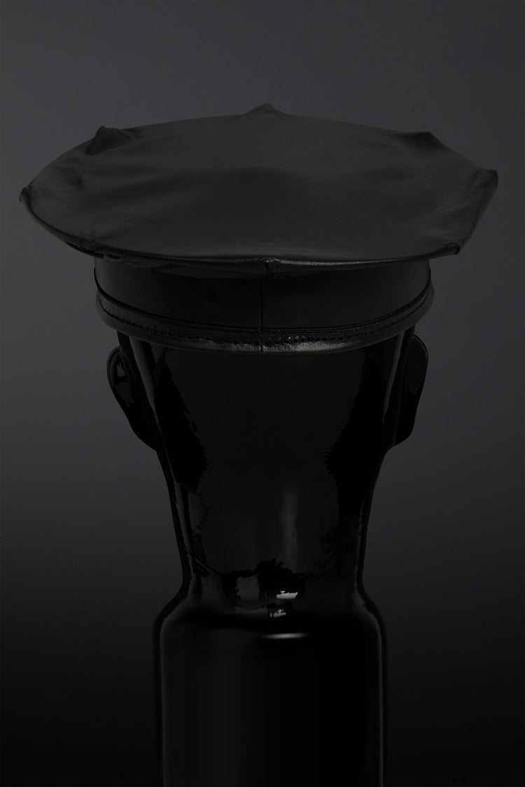 Black leather hat on a black mannequin against a dark background