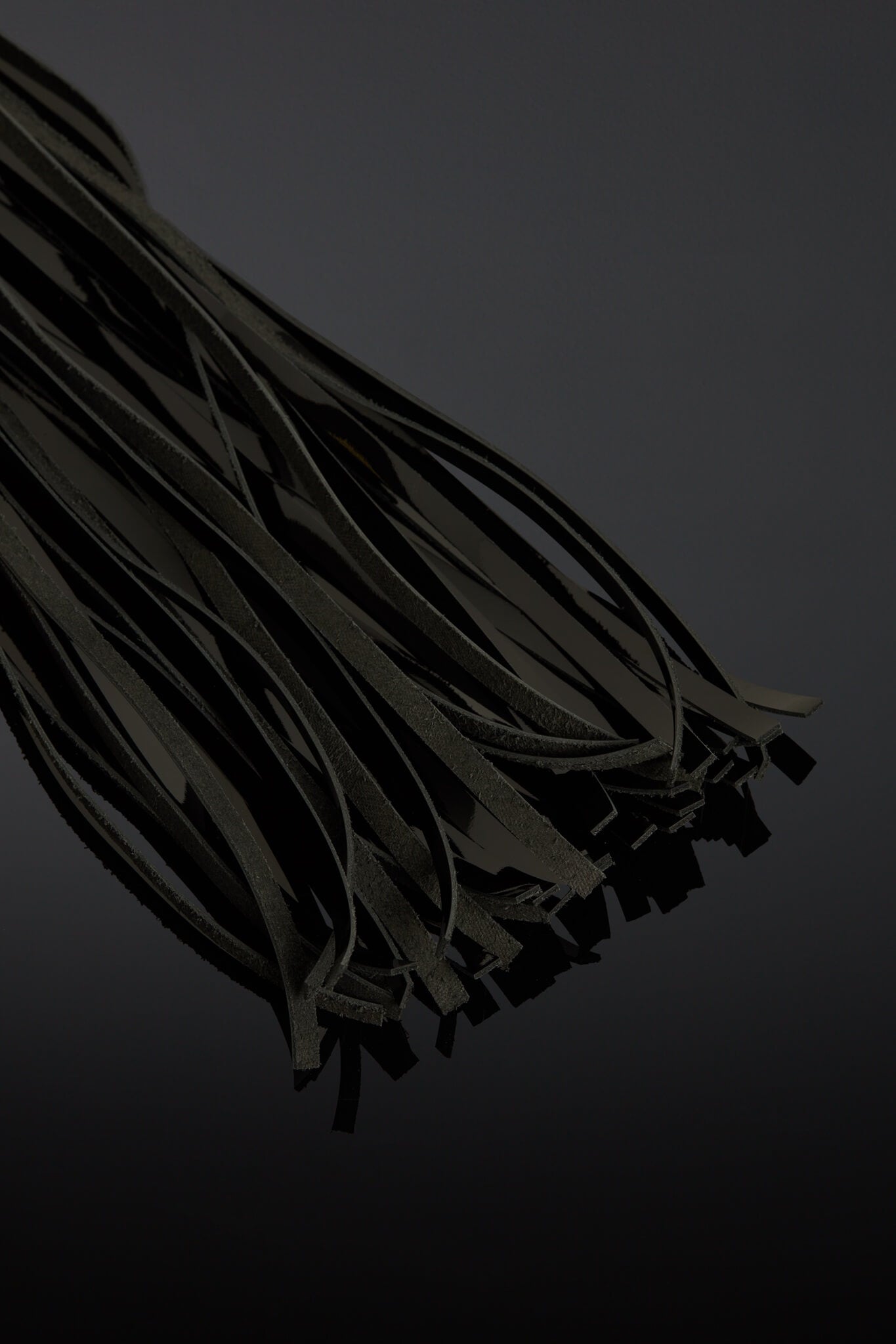Dark black leather tails on a black background