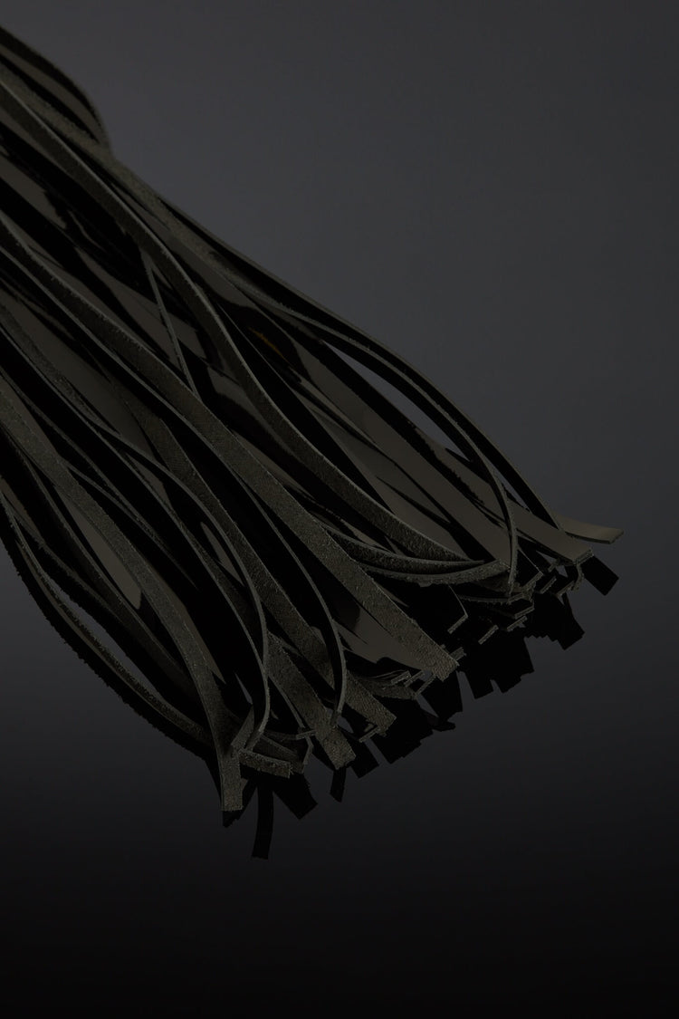 Dark black leather tails on a black background